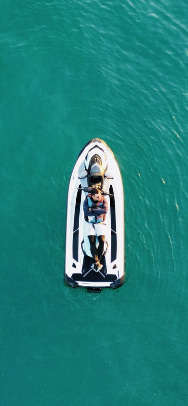 Vista aérea por drone de jetski no mar verde-esmeralda do Guarujá